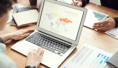 Graphic of a world map on a laptop with workers