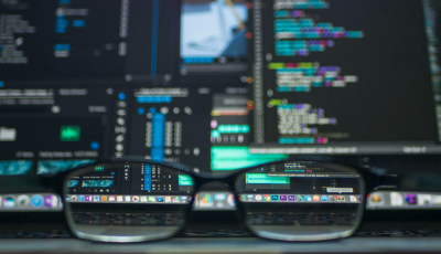 Glasses in front of multiple screens with data