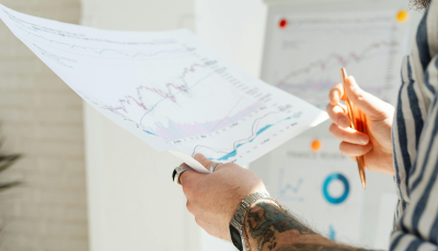 Person holding paper with graphs on it