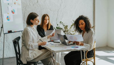 a-group-of-women-sitting-at-a-desk-working-together